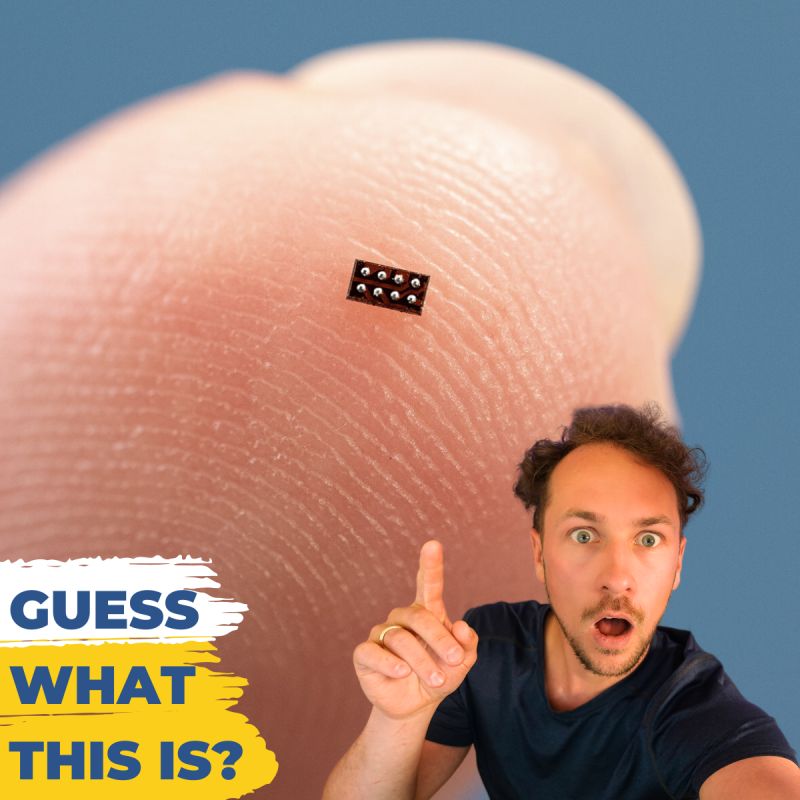A microchip placed on Lukas's fingertip with a surprised individual pointing at it.